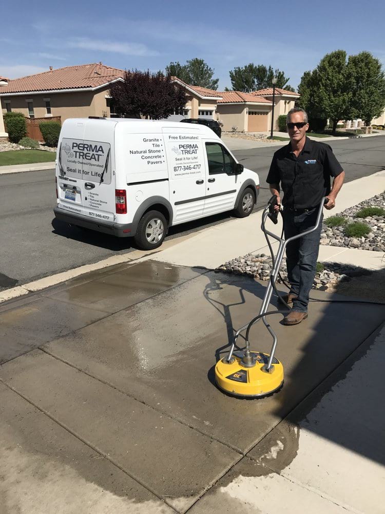 02-1-1 A man in sunglasses pressure washes a concrete sidewalk with a yellow machine, next to a white "PERMA TREAT" van.
