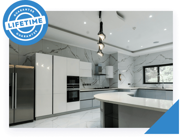 A modern kitchen with white cabinets, marble-patterned walls, and a blue "LIFETIME GUARANTEE" badge.
