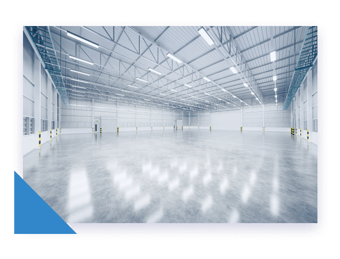 A vast, empty, modern warehouse with a polished concrete floor reflecting the bright fluorescent lights above.