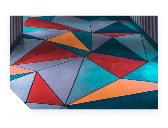 A surface covered in a colorful geometric pattern of red, orange, teal, and gray triangles outlined in black.