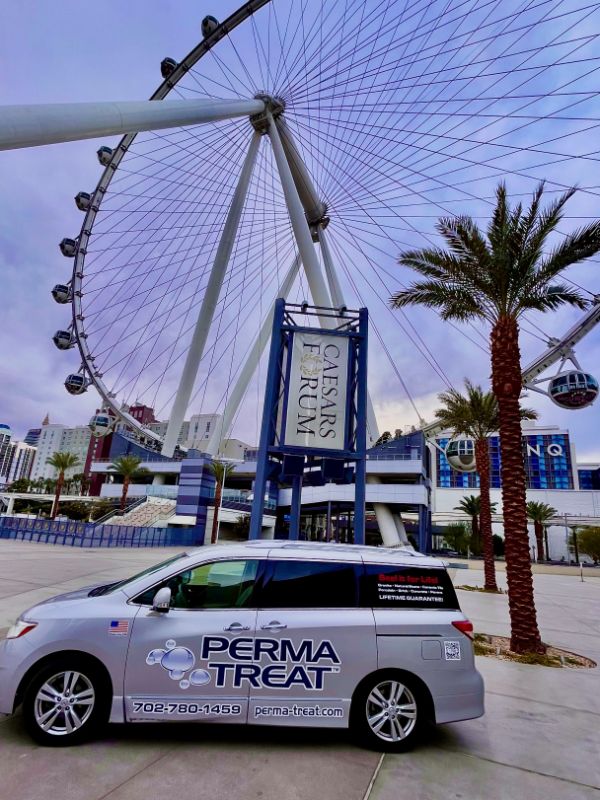 image_50453761 A silver "PERMA TREAT" van is parked in front of the High Roller Ferris wheel and "CAESARS FORUM" sign.