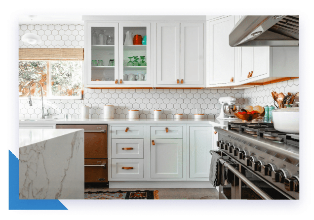 A modern white kitchen features hexagonal tile backsplash, stainless steel appliances, and a marble island.