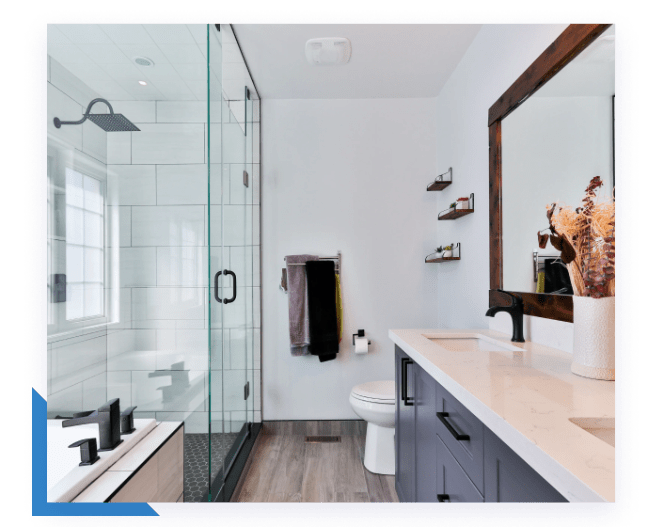A modern bathroom features a glass shower, white tiled walls, a dark wood vanity, and a large mirror.